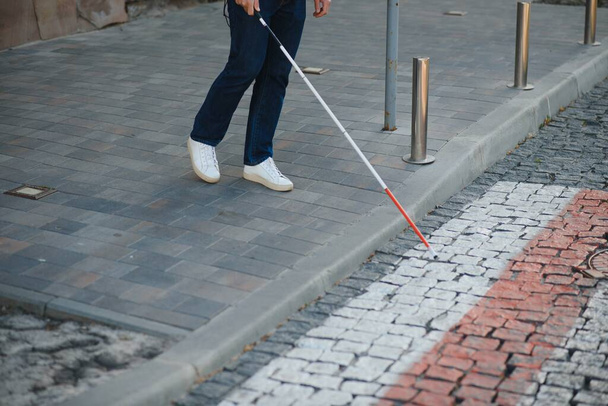 Close-up van een blinde Man permanent met witte stok op straat. - Foto, afbeelding
