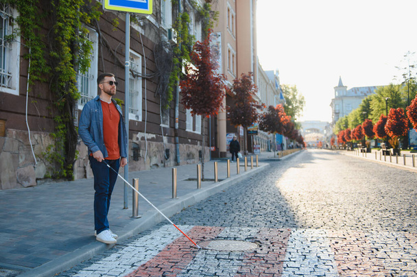 Blind man. People with disability, handicapped person and everyday life. Visually impaired man with walking stick - Photo, image