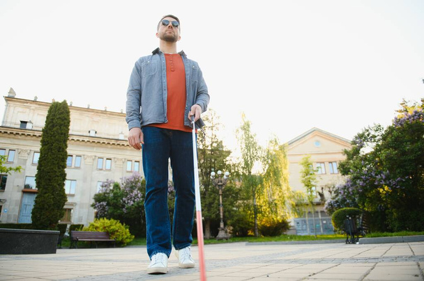 Blind Man Walking On Sidewalk Holding Stick. - Фото, изображение