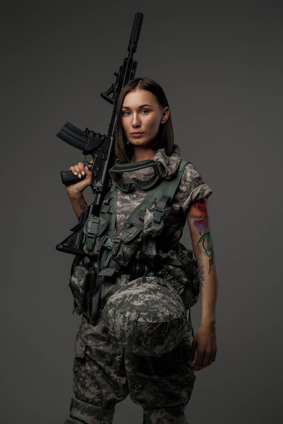 Bruin harige vrouw met geweer op haar schouder - Foto, afbeelding