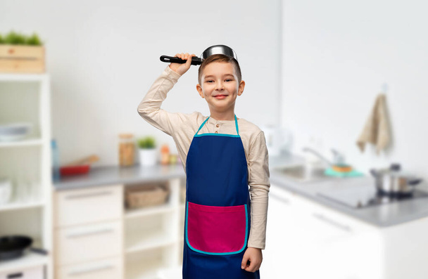 happy boy playing with saucepan in kitchen - Zdjęcie, obraz