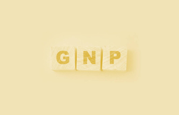 BNP bruto binnenlands product woord gemaakt met houten blokken op gele achtergrond. - Foto, afbeelding