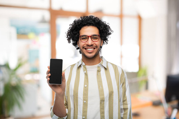 happy man in glasses showing smartphone at office - Zdjęcie, obraz