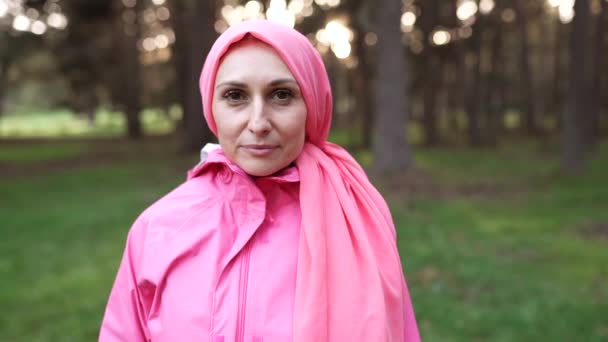 zralé žena rakovina přeživší při pohledu na kameru s růžovou šálu - Záběry, video