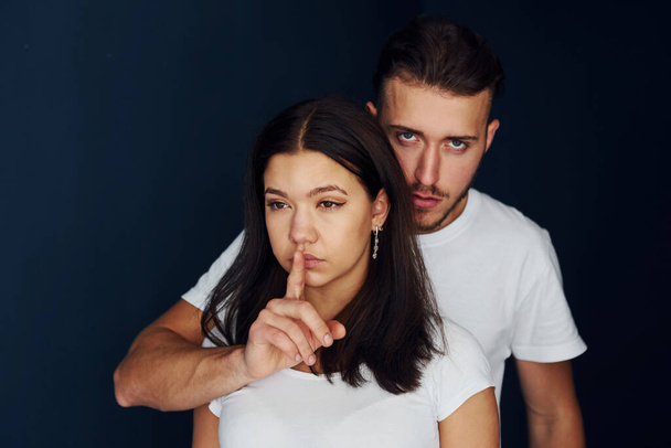 Be quiet. Violent aggressive young man threatening his girlfriend at home. - Valokuva, kuva