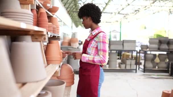 kobieta żłobek pracownik wprowadzenie roślin i garnki do sprzedaży - Materiał filmowy, wideo