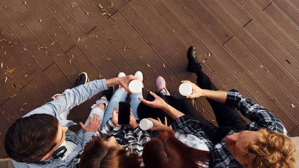 Top view of group of young cheerful friends that is outdoors having fun together. - Fotoğraf, Görsel