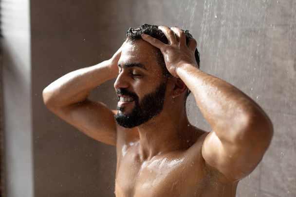 Guapo feliz joven árabe masculino modelo tomando ducha caliente - Foto, imagen