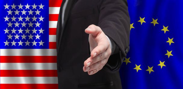 Vlajky USA a Evropské unie s otevřenou mužskou rukou pro podání ruky - Fotografie, Obrázek