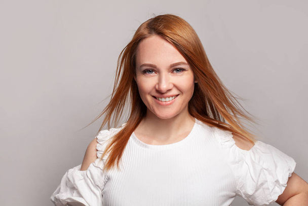 Pozitív nő vörös hajú divat modell hosszú sima szél fúj piros frizura - Fotó, kép