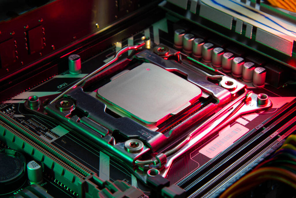 центральный процессор компьютера на материнской плате при красном и зеленом освещении - Фото, изображение