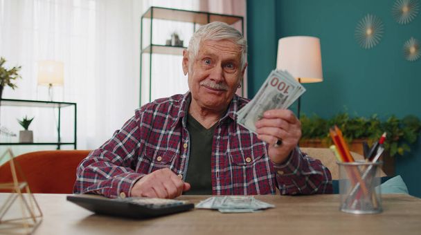 Ευτυχής παππούς άνθρωπος καταμέτρηση των χρημάτων σε μετρητά δολάρια σχεδιασμό έξοδα οικονομικού προϋπολογισμού - Φωτογραφία, εικόνα