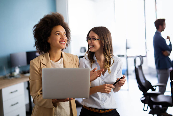 Happy multiethnic success business women working together online on a laptop in corporate office. - Fotoğraf, Görsel
