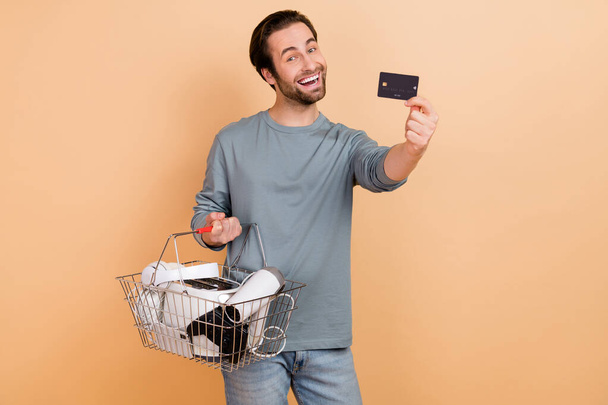 Photo of young man make shopping consumer bank card black friday benefit isolated over beige color background - Fotó, kép