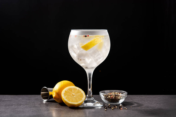 gin tonic cocktail drankje in een glas op zwarte achtergrond - Foto, afbeelding