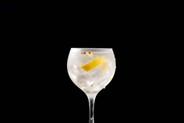 Gin tonic cocktail drink into a glass on black background - Photo, Image