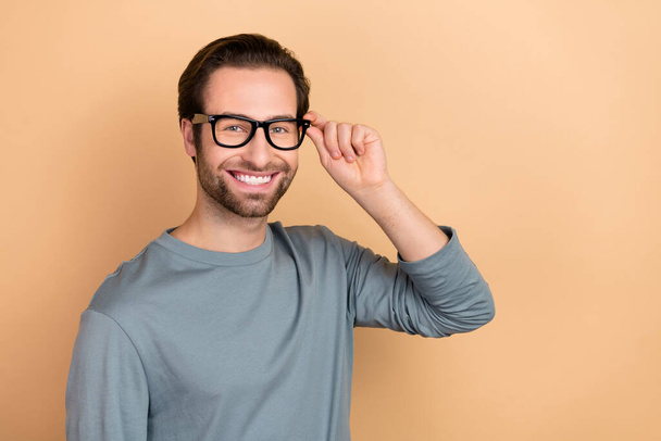 Photo of young cheerful man hand touch specs clever attorney banker isolated over beige color background - Fotoğraf, Görsel