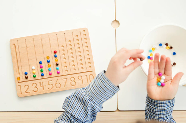 Montessori Beads Board. Aprender a contar e escrever números, preparar a criança para a aritmética mental, desenvolver um senso de ordem, foco, coordenação e precisão. - Foto, Imagem