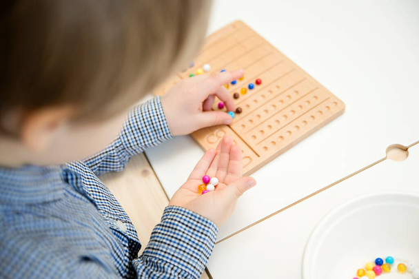 Montessori Beads Board. Aprender a contar e escrever números, preparar a criança para a aritmética mental, desenvolver um senso de ordem, foco, coordenação e precisão. - Foto, Imagem