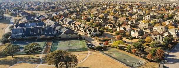Panorama widok z lotu ptaka duży trawiasty park w pobliżu kompleksu kortów tenisowych w dzielnicy mieszkalnej z kolorowym liści jesieni w pobliżu Dallas, Teksas, Ameryka. Ekskluzywne zaplecze stowarzyszenia właścicieli domów - Zdjęcie, obraz