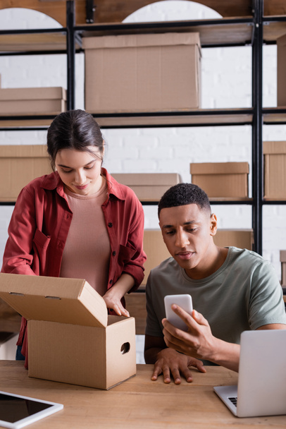 Interracial sellers using devices and packaging carton box in online web store  - 写真・画像