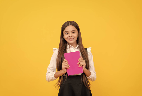 szczęśliwy nastolatek dziewczyna w szkole mundur trzymać książki, z powrotem do szkoły - Zdjęcie, obraz