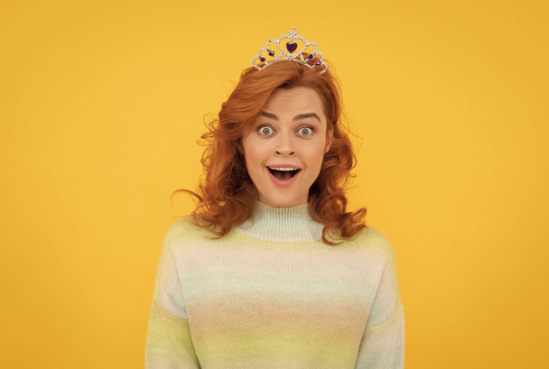 amazed redhead woman in queen crown, surprise - 写真・画像