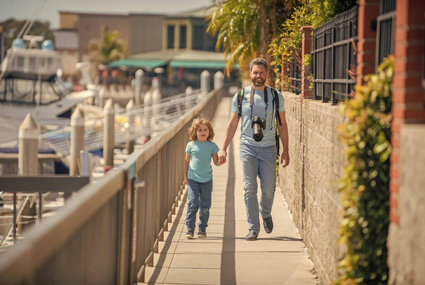 Leisure travelers. Man and boy promenade holding hands. Leisure activities. Father and son child - Photo, image