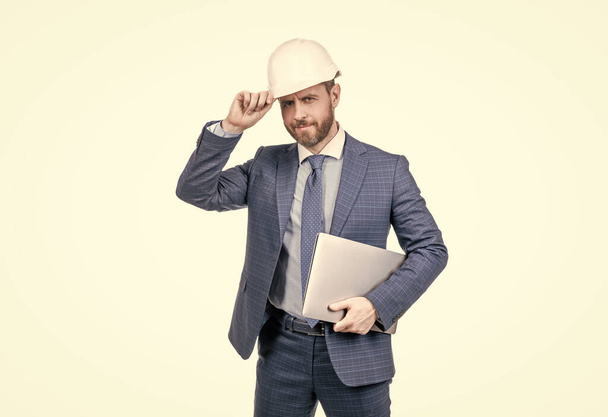 уверенный бизнесмен в костюме и шлеме провести компьютер изолированы на белом, безопасность бизнеса - Фото, изображение