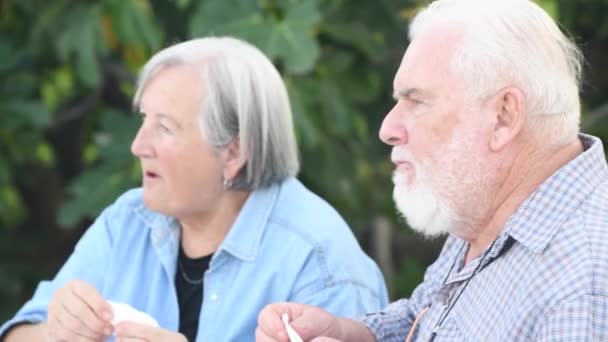 Ηλικιωμένο ζευγάρι τρώει ψωμί και ζελέ εξωτερική - Πλάνα, βίντεο