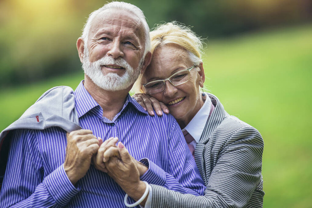 Πορτρέτο του όμορφου ηλικιωμένου ζευγαριού ποζάρουν στο πάρκο - Φωτογραφία, εικόνα
