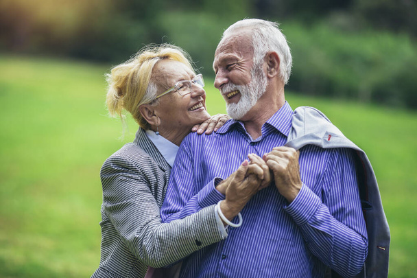 Portrait of beautiful senior couple posing in the park - Photo, Image