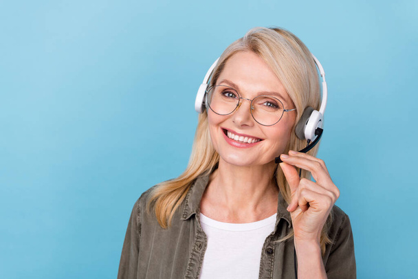 Photo of confident agent middle aged lady speak clients dispatch mic advise helpdesk isolated blue color background - Fotografie, Obrázek