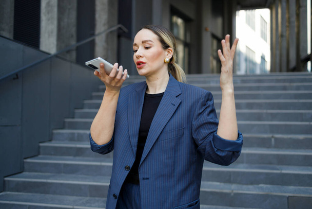 Business woman talking on the phone through the speakerphone - Foto, Imagen