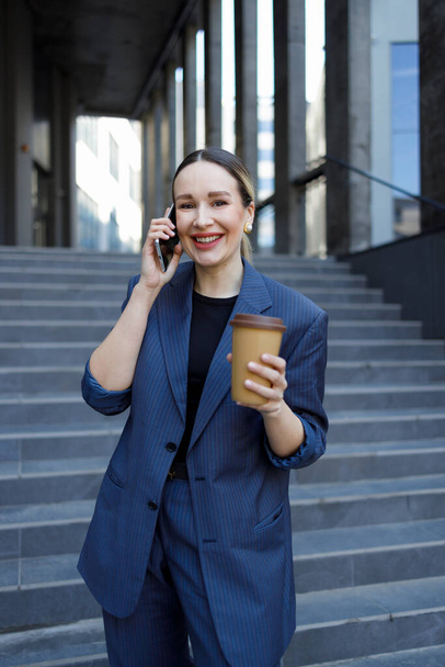 Veselá žena s hrníčkem kávy v ruce a telefonem. - Fotografie, Obrázek