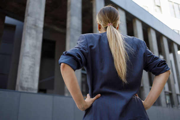 Back view of a business woman looking up at an office building - Fotografie, Obrázek