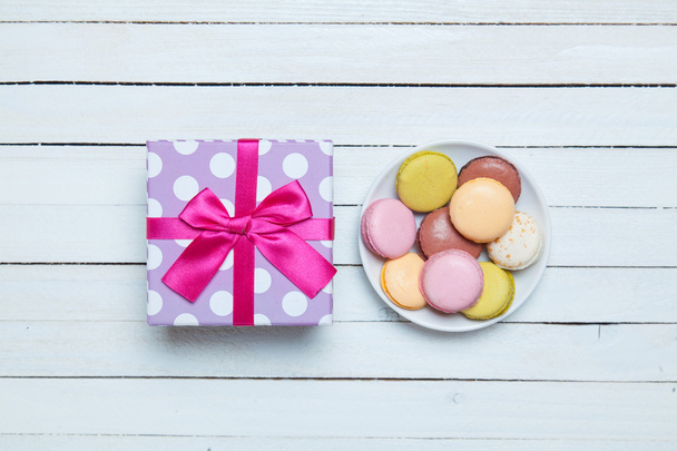 Macaron and gift on white table. - Photo, Image