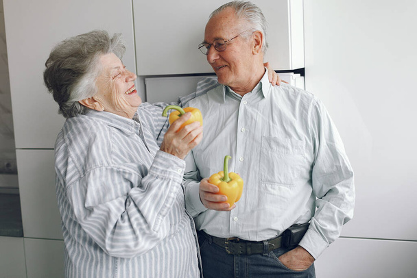 Beautiful old couple prepare food in a kitchen - Fotoğraf, Görsel