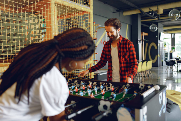 International couple playing a table football in a club - Foto, Bild