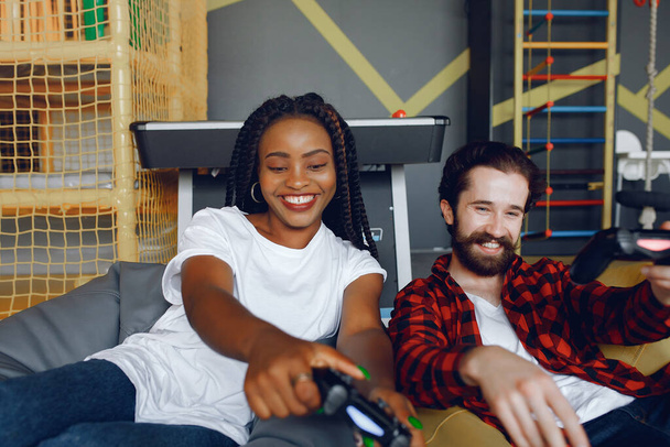 International couple playing a video games - Photo, Image