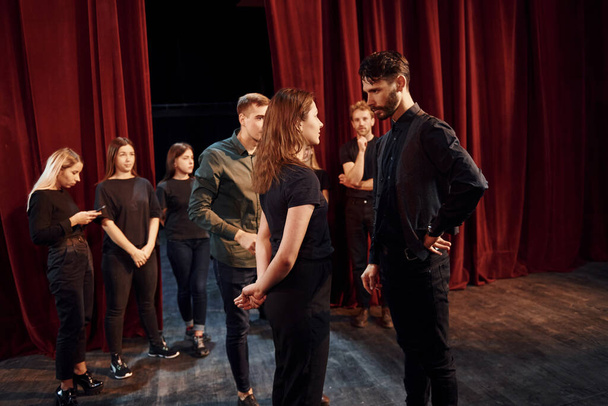 Eye contact practice. Group of actors in dark colored clothes on rehearsal in the theater. - Fotografie, Obrázek