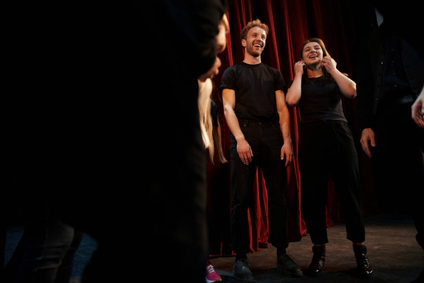 Practice in progress. Group of actors in dark colored clothes on rehearsal in the theater. - Foto, Imagen