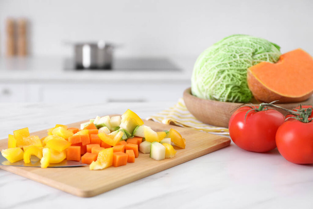 Different raw vegetables on white marble table in kitchen - Foto, Imagen