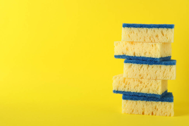 Stacked cleaning sponges on yellow background. Space for text - Φωτογραφία, εικόνα