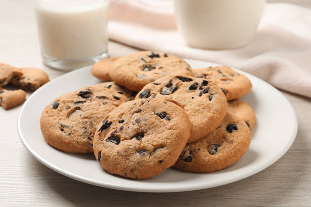 Plate with delicious chocolate chip cookies on white wooden table, closeup - Foto, immagini