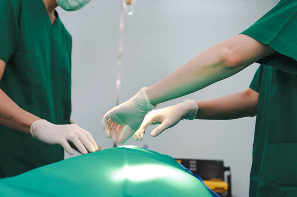 Ein professionelles Team asiatischer Chirurgen führt Operationen an einem Patienten durch, der im Operationssaal eines Krankenhauses auf einem Bett liegt. Medizinische Konzepte. Notoperation - Foto, Bild