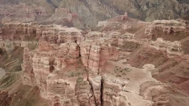 Grand Canyon Charynissa. Kivet sedimenttikivistä. Valtavia halkeamia kivissä. Maa on punainen-oranssi. Huippunäkymä lennokista. Keskuksessa on tie. Maakerrokset eri väreissä. - Materiaali, video
