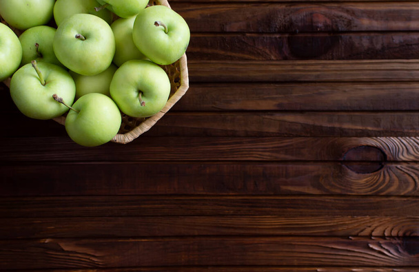 Lots of ripe green apples on a wooden background. - Fotografie, Obrázek