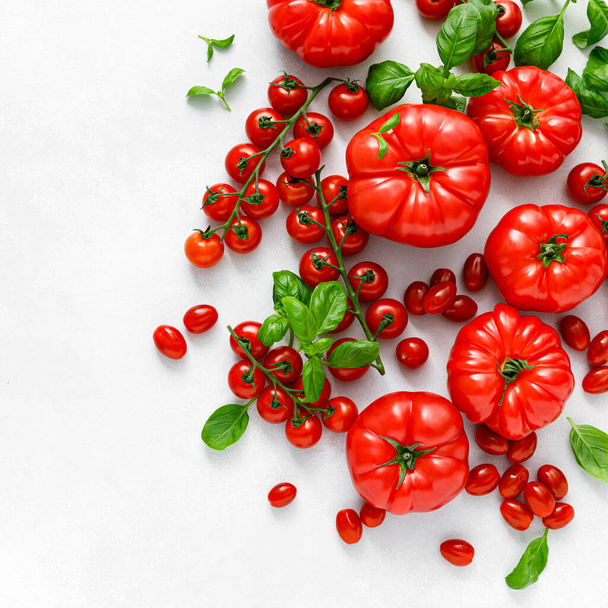 Tomatoes and basil on white background, top view, flat lay - Foto, afbeelding