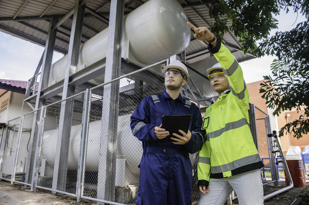 Engineers work place to keep liquid helium,preventive maintenance schedule checking,Thailand people,Technicians and engineers discuss work together. - Foto, Imagen